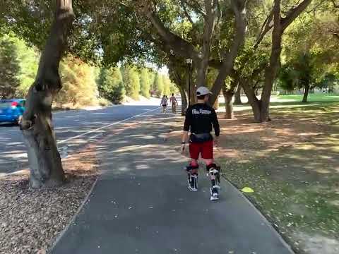 A person walks with assistance from a portable ankle exoskeleton outside.