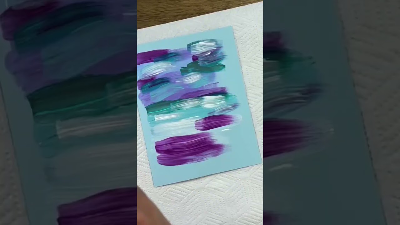 Thick body acrylic paint used to created abstract art on blue card for