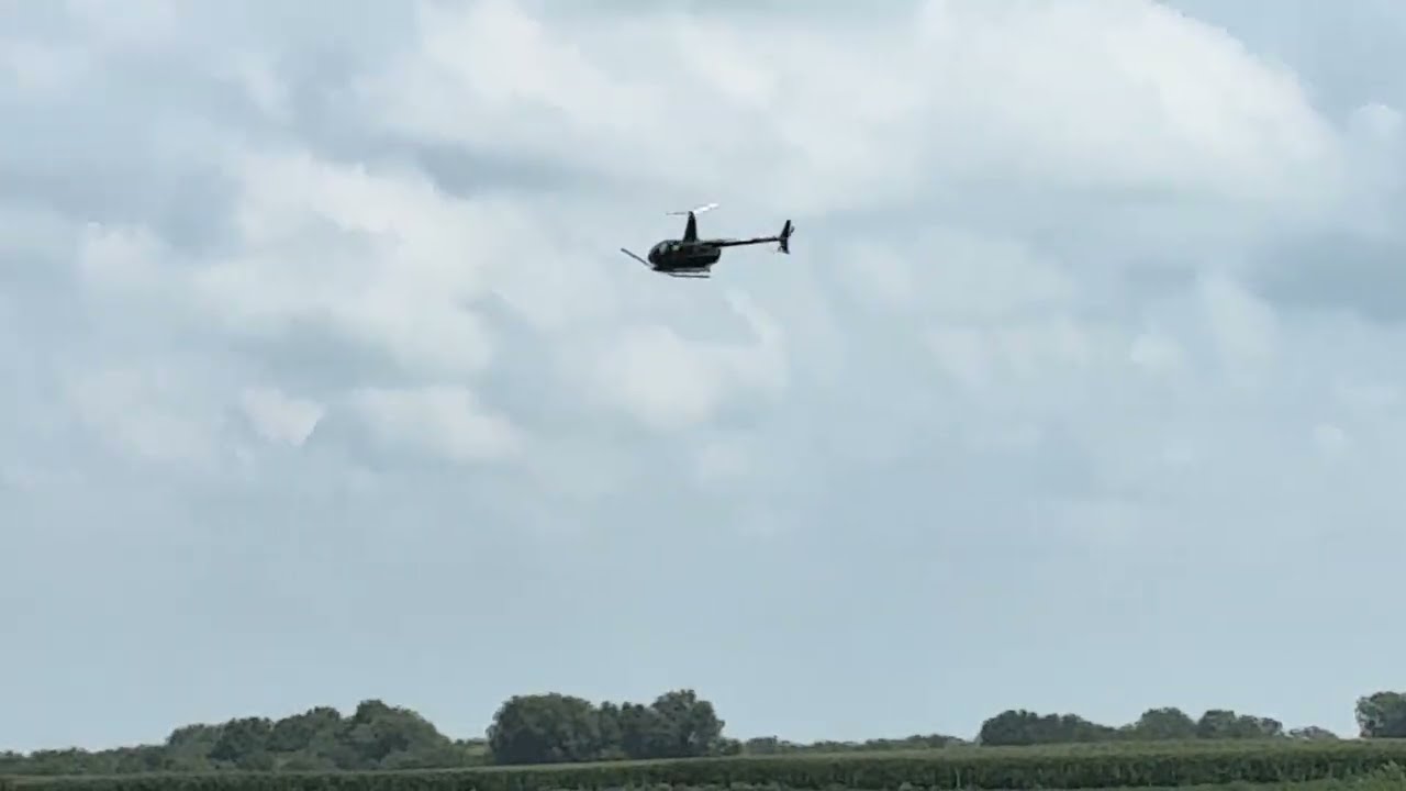 Cropfield helicopter duster-north central Illinois. Spraying pesticide/insecticide over the crop.