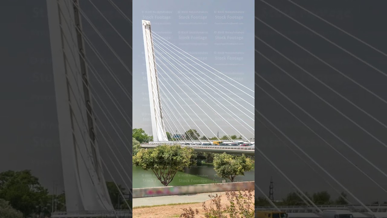 Alamillo Bridge with tall pylon and steel cables crossing over Guadalquivir River timelapse