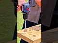 drilling multiple large holes into a wooden board using a powerful cordless drill and flat spade bit