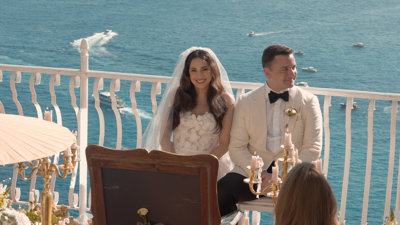 Bride and groom seated at their ceremony on a terrace above the sea in Positano on the Amalfi Coast