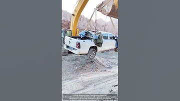 Excavators lift pickup trucks. The sudden breakage of the strap caused the vehicle to fall to  grou
