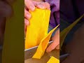cutting and slicing sweet ripe yellow pumpkin pieces using a sharp kitchen knife on a cutting board