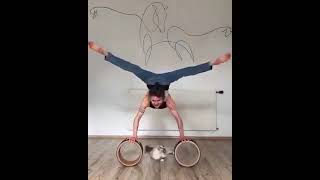 Woman puts on her jeans while doing a handstand on rollers