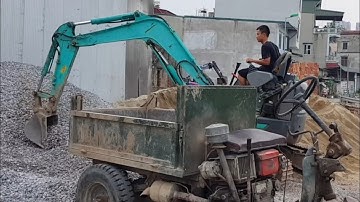 Excavator to scoop rocks onto three-wheeled tractor