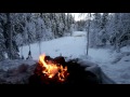 Crackling fire in the snow overlooking a frozen river in deep winter