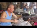 Chinese barber practising the rare art of cutting hair with hot tongs