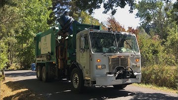 A Peterbilt 320 Labrie Automizer roaring down a country road