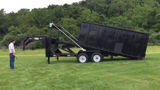 Bison rolloff trailer pulling container on and tarping.