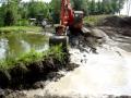 Excavator busting a dam