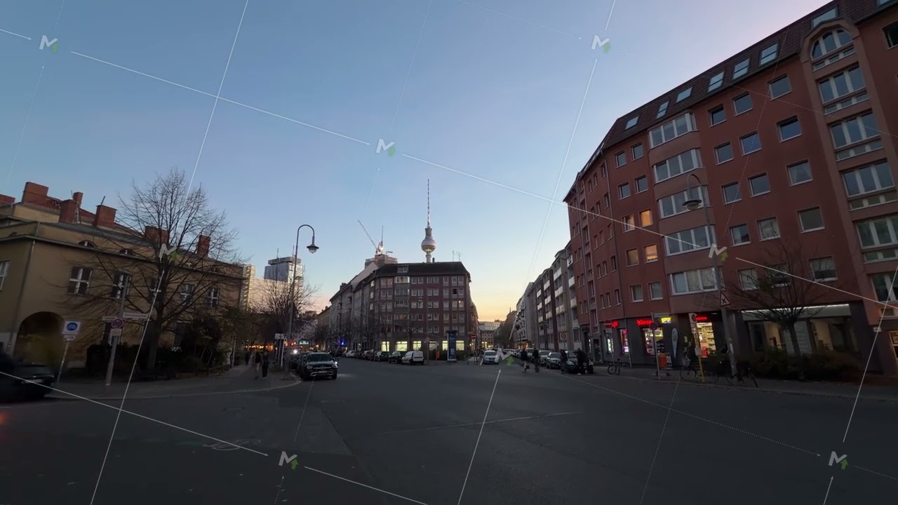 Wide angle, handheld perspective of a street with traffic in Berlin, Germany during golden hour