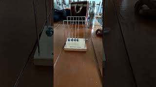 principles of conservation of momentum and conservation of energy in physics (Newton's cradle)