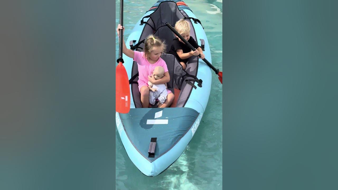 Kids are floating in a kayak in the pool Kids are floating in a kayak in the pool