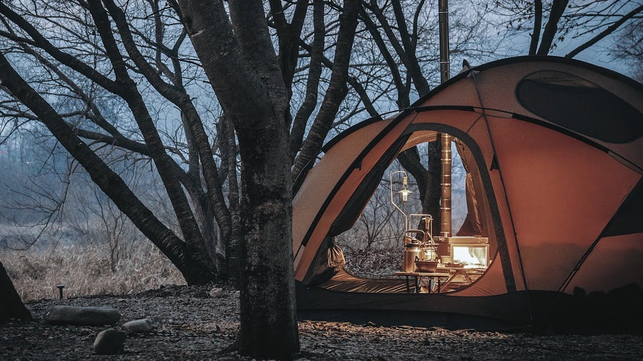 Горячая палатка кемпинг перед рекой зимой