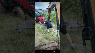 Excavator rescues Kubota tractor-trailer stuck in mud