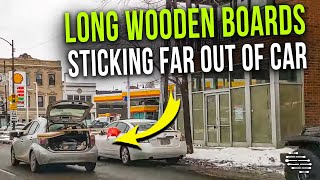 Subcompact Car Driving With Long Wooden Boards Sticking Far Out