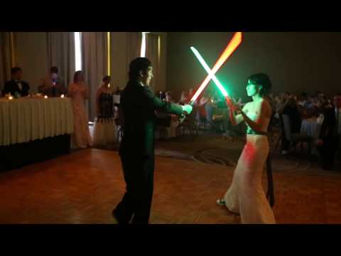 Bride and Groom simulating a lightsaber duel at their wedding