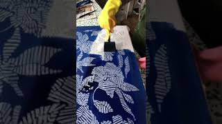 Adding blue dye to a batik