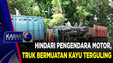 HINDARI PENGENDARA MOTOR, TRUK BERMUATAN KAYU TERGULING | KABAR JEMBER