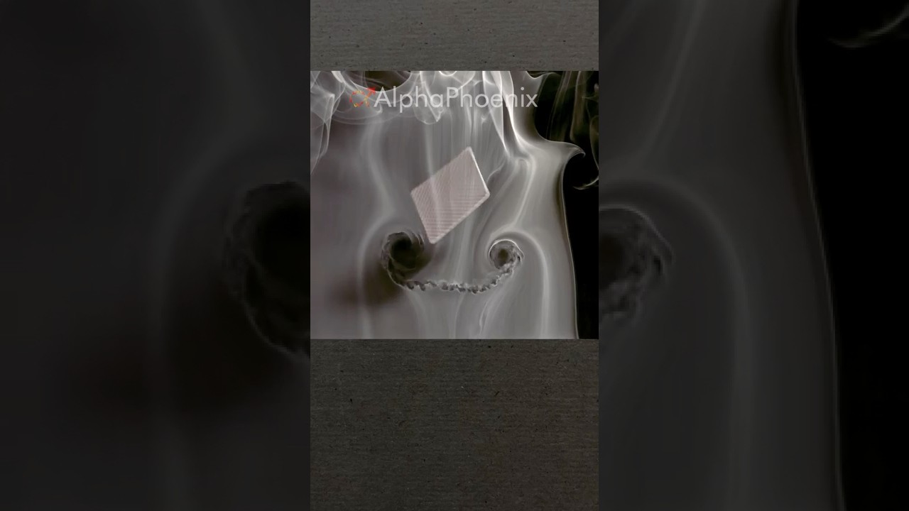 Flying playing card through smoke in slow motion
