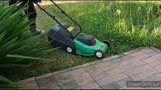 A boy cutting the grass using lawnmower