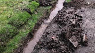 A French Drain or land drain running with water in Wilmslow