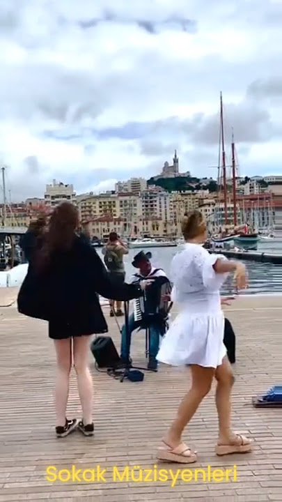 Musician playing accordion and girls dancing on the street. Müzisyen çalıyor ve kızlar dans ediyor.