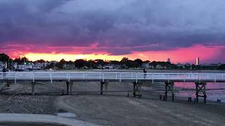 A storm rolls over Boston at sunset as seen from Wollaston Beach