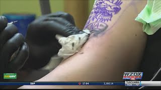 Tattoo artist helping clients spot skin cancer