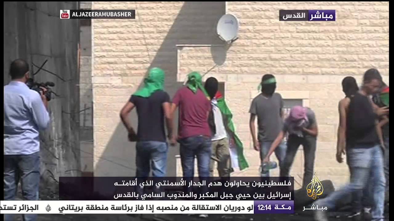 فلسطينيون يحاولون هدم جزء من الجدار العازل في بلدة أبوديس بالقدس