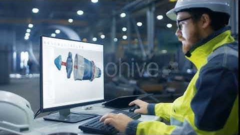 Inside the Heavy Industry Factory Industrial Engineer Works on the Personal Computer