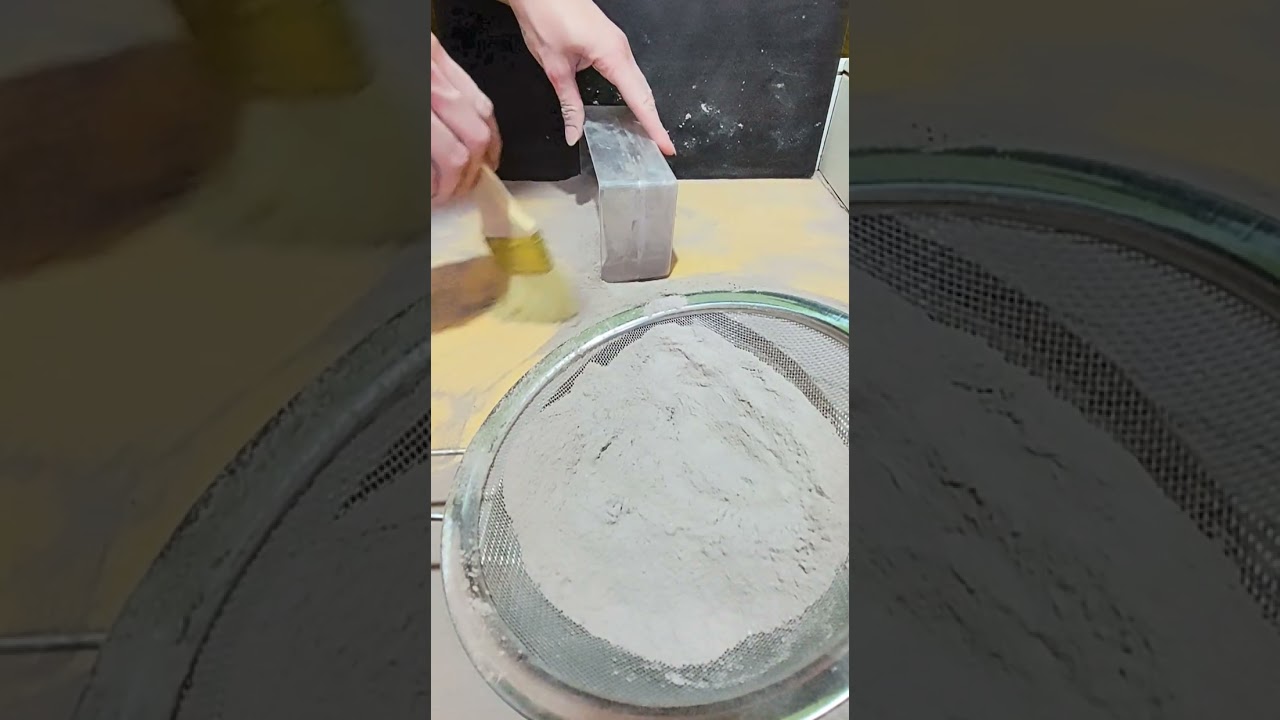 Pebbles with pink gymchalk, dusty crushing and sifting, brush sweeping, side view