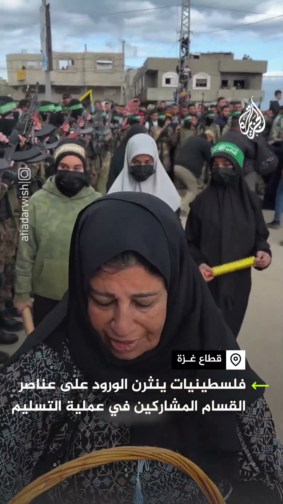 فلسطينيات ينثرن الورود على عناصر القسام المشاركين في عملية التسليم
