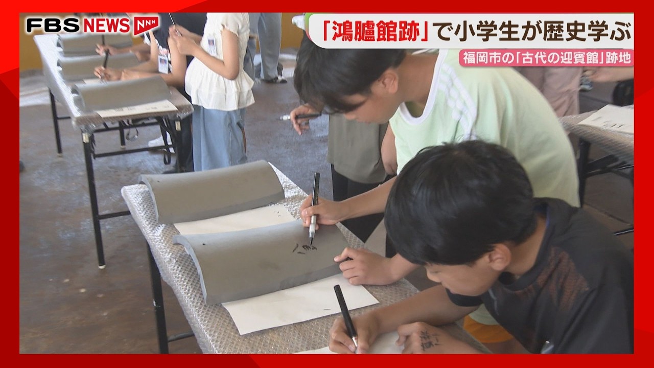 Elementary students write their names on roof tiles at the Korokan