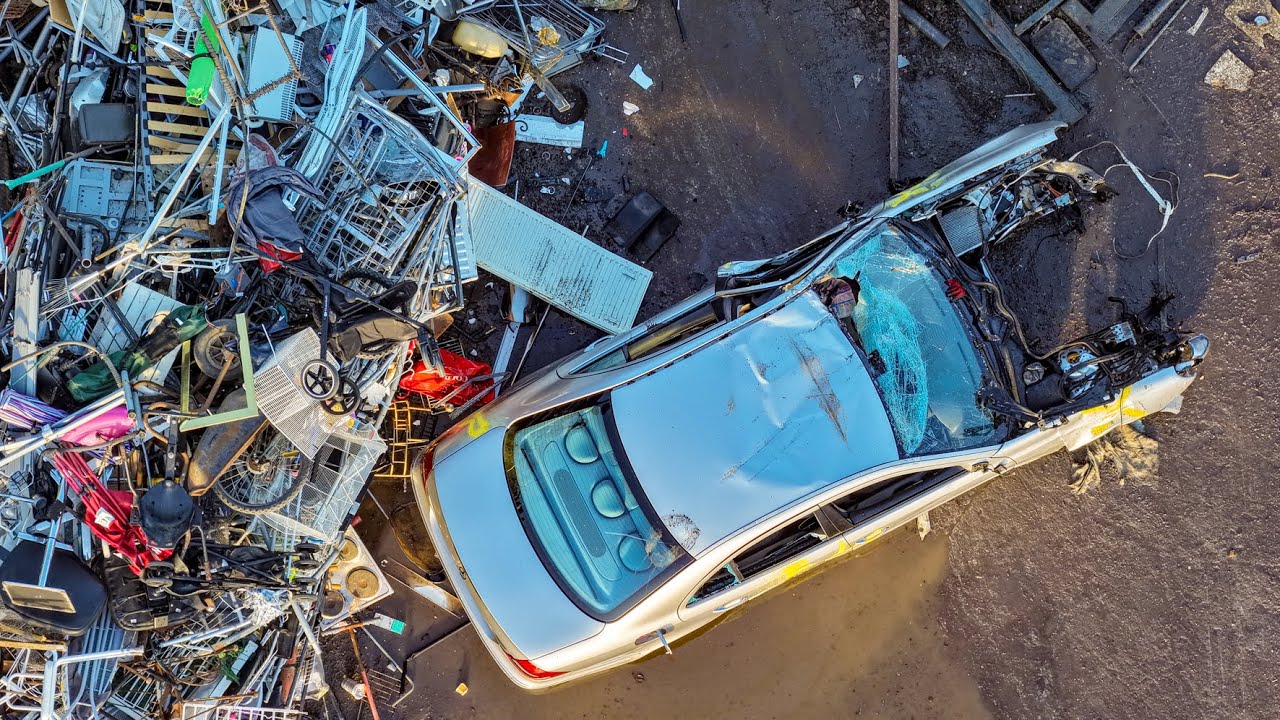 Drone View of Scrapyard: Powerful Machine Lifts Cars & Scrap Metal into a Pre-Shredder