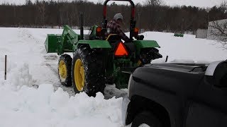 John Deere 5055E pulling out Chevy Truck and plowing wet snow
