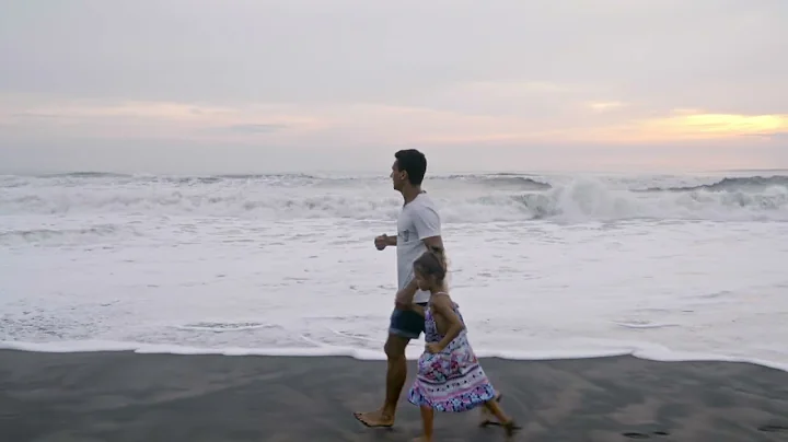 A Father Running With His Daughter On The Beach Sand