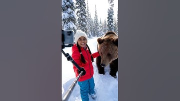 The small girl create a blog video and walking with bear in a snow ground , soft bokeh 