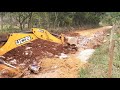 Retroescavadeira elimina poça dàgua utilizando entulho(Backhoe removing puddle water using debris)