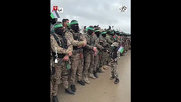 بزيه العسكري طفل غزي يصافح مقاتلي كتائب القسام في موقع تسليم المحتجزين الإسرائيليين 