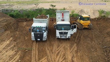 China dump truck pouring wet soil to slope - Bulldozer hard working push the wet soil into water