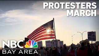 Protesters march to Coast Guard Island to oppose Trump's immigration policy