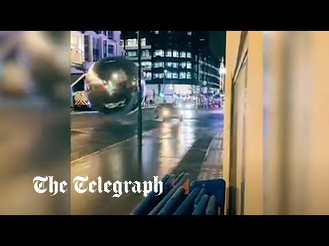 Cars dodge massive baubles rolling down central London street