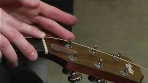 How to Change the Strings on an Acoustic Guitar : How to Lock the Guitar String into the Tuning Post