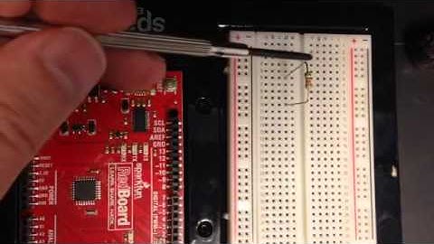 Connecting two resistors in series on an electronic breadboard.