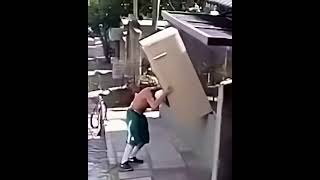Man Carries a Fridge On His Shoulder While Riding a Bike [HD]