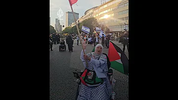 امرأة تواجه الشرطة الألمانية ومؤيدين لإسرائيل في برلين وترفع العلمين الفلسطيني واللبناني 