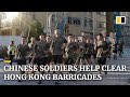 Chinese soldiers and residents help clear streets after a week of intense protest in Hong Kong