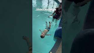 Baby Cooper completes the slide challenge during infant aquatics class